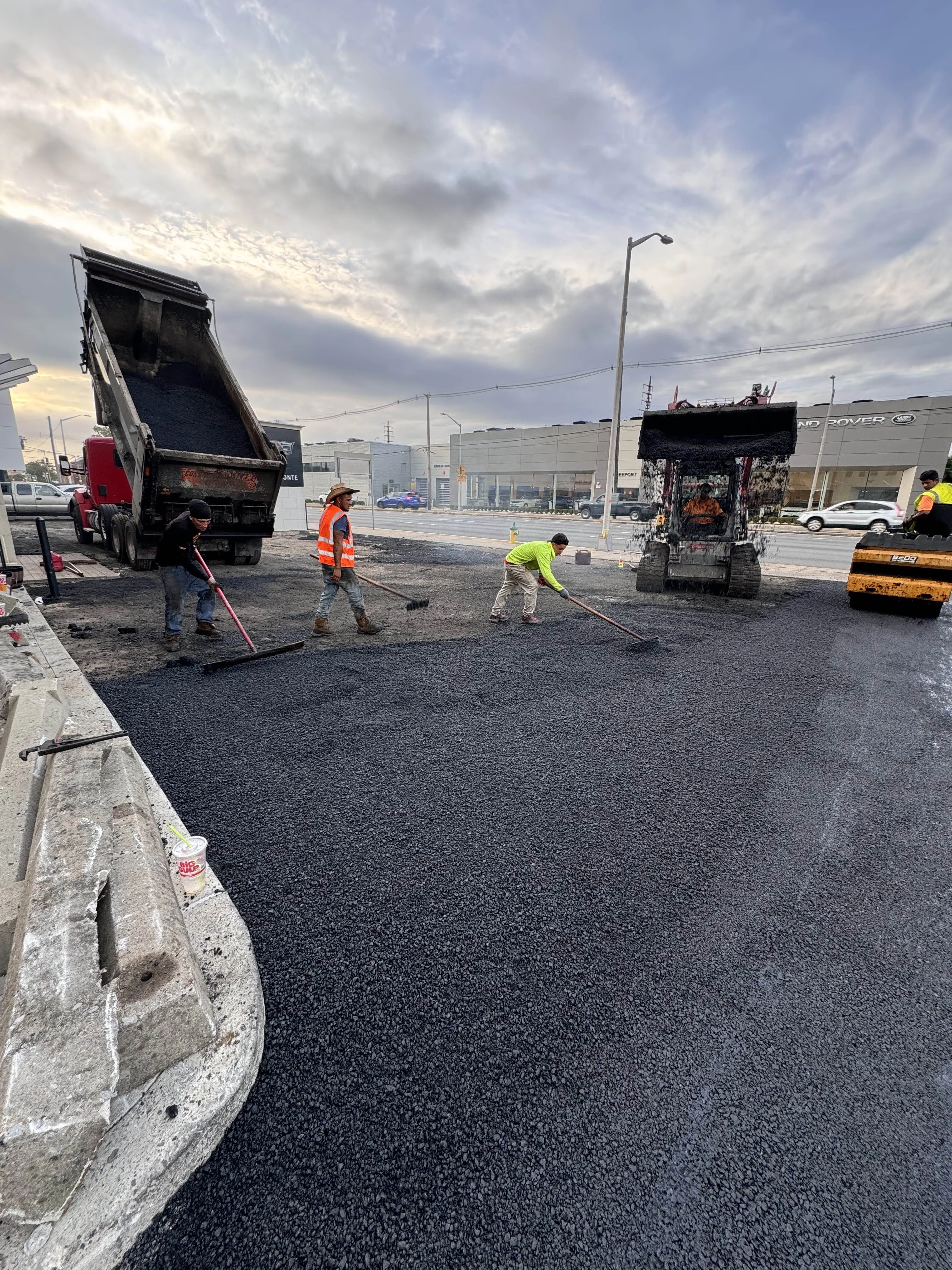 Asphalt paving crew working at Paul Conte Cadillac dealership in Nassau County